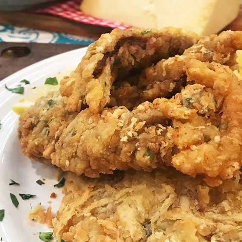 Milanesas de carne rebozadas con queso con ensalada de choclo