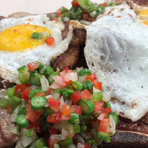 Bifes anchos a la chapa con criolla espárragos y papas a la crema