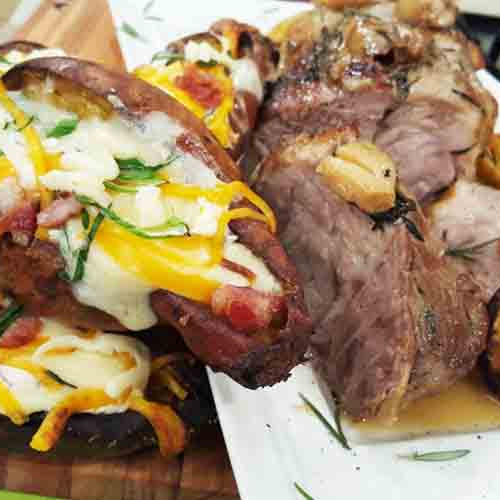 Bondiola braseada con batatas rellenas de quesos y verdeo