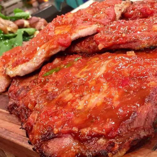 Churrasquitos de cerdo laqueados con barbacoa y papas salteadas con espinacas