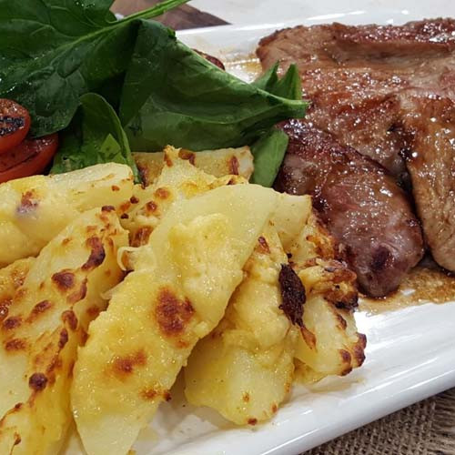 Churrasquitos de cerdo laqueados con papas con queso y panceta