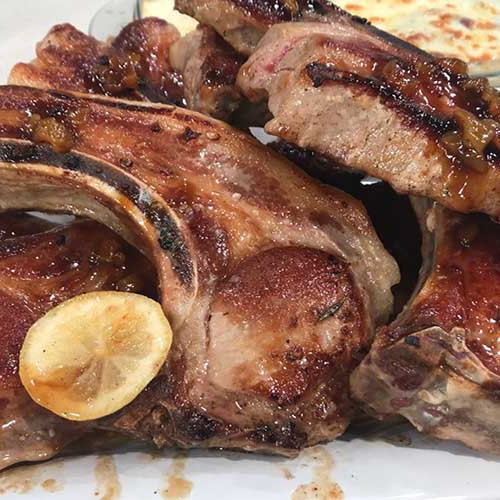 Costillas de cerdo a la chapa con salsa de cerveza negra y vegetales gratinados