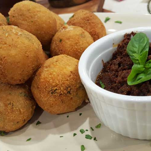 Croquetas de pollo, jamón y salsa blanca con pesto de albahaca