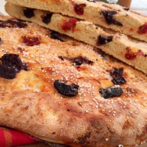 Focaccia redonda de harinas mixtas con aceitunas y tomates secos