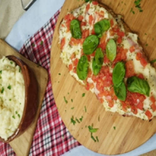 Milanesa cubierta con salsa blanca con puré y milanesa cubierta con mozzarella con papas a la crema