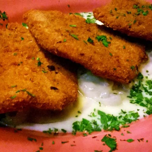 Milanesas de carré de cerdo y bife de chorizo con salsa de quesos y papas y batatas fritas