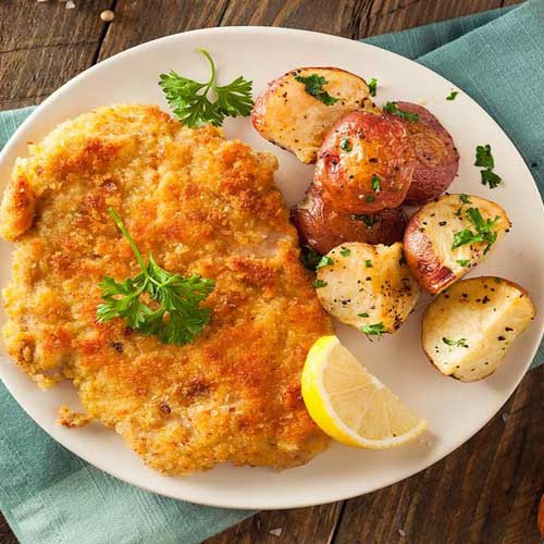 Milanesas de costilla de ternera fritas con papas parmesanas