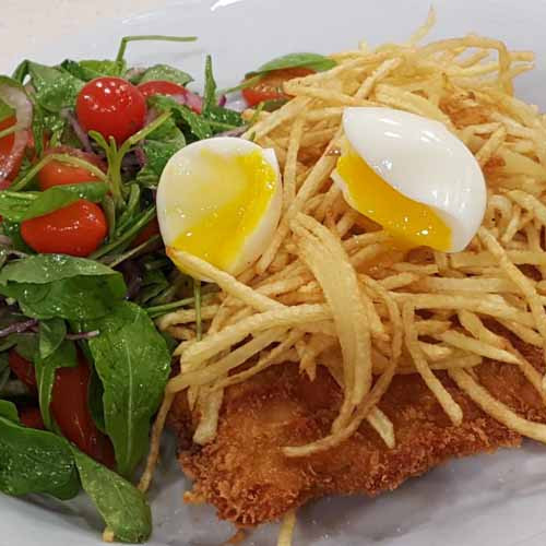 Milanesas de nalga de cerdo con papas fritas, ensalada y huevos poché