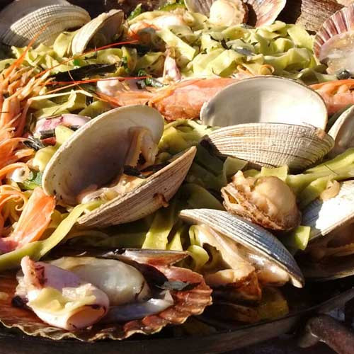 Paella de mariscos y pasta de algas