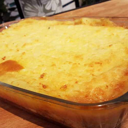 Pastel de papas, jamón y mozzarella con carne cortada a cuchillo