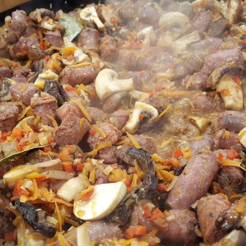 Polenta blanca con salchichas estofadas en paella