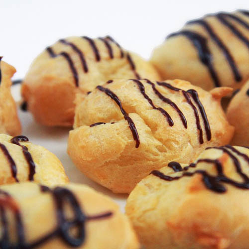 Profiteroles rellenos con helado y bañados en chocolate