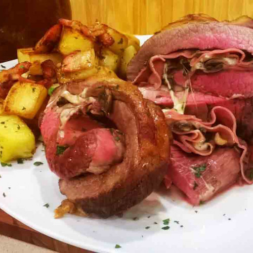 Tapa de asado enrollada rellena de mortadela con papas doradas