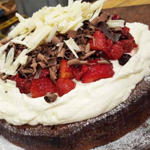 Torta brownie con dulce de leche, crema y compota de frutos rojos