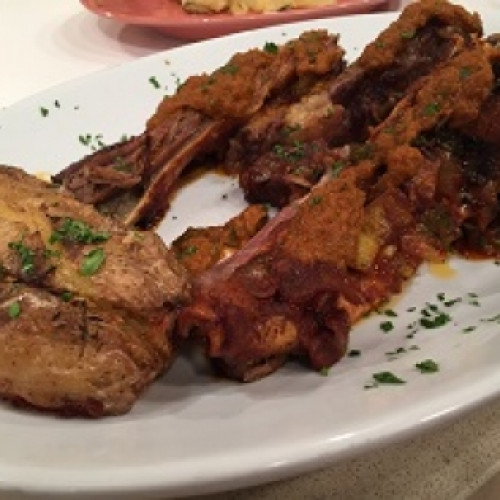 Vacío adobado al horno con papas aplastadas