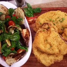 Milanesas rebozadas en queso con ensalada de vegetales asados y hojas verdes