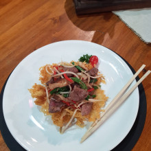 Salteado oriental sobre canasta de papas fritas